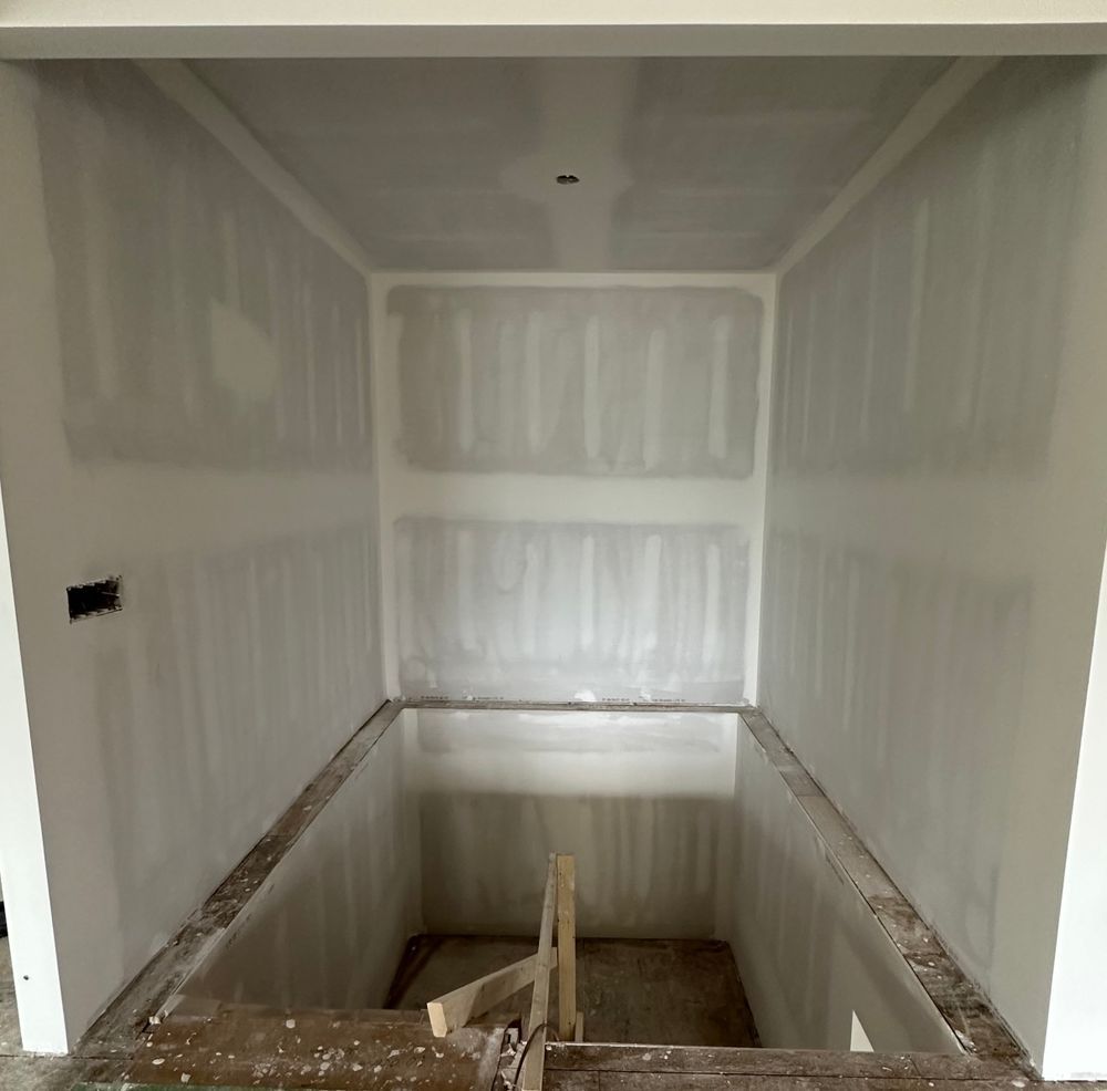 A room with white walls and a staircase in it