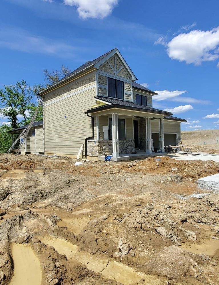 A house is being built in the middle of a dirt field.