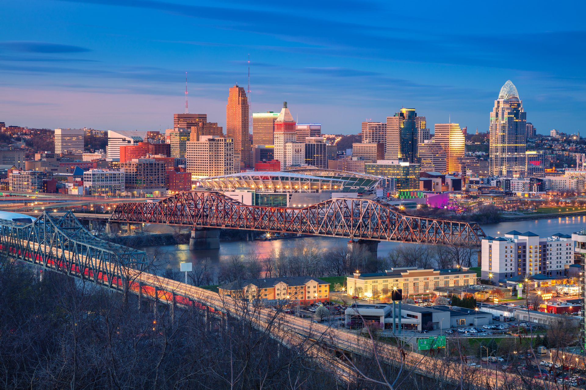 An aerial view of a city at night with a bridge over a river.