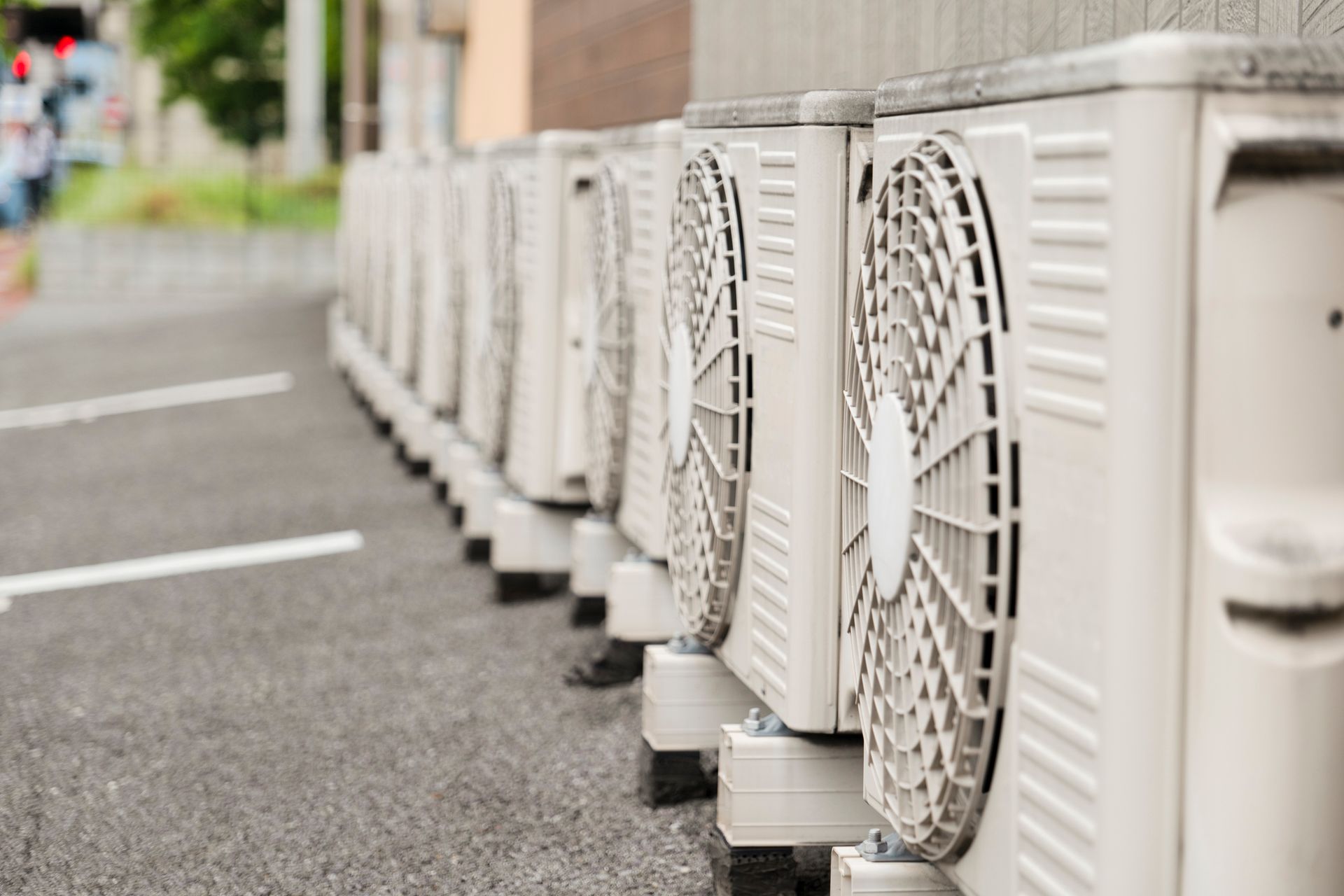Outdoor Units of Air-Conditioners Lined Up by a Building Outdoor Units of Air-Conditioners Lined Up by a Building