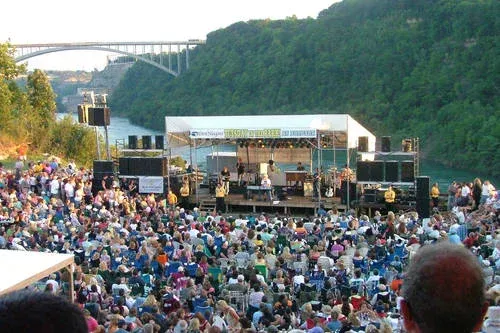 A large crowd of people are watching a concert on a stage