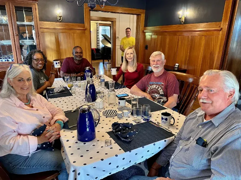 A group of people are sitting around a long table.