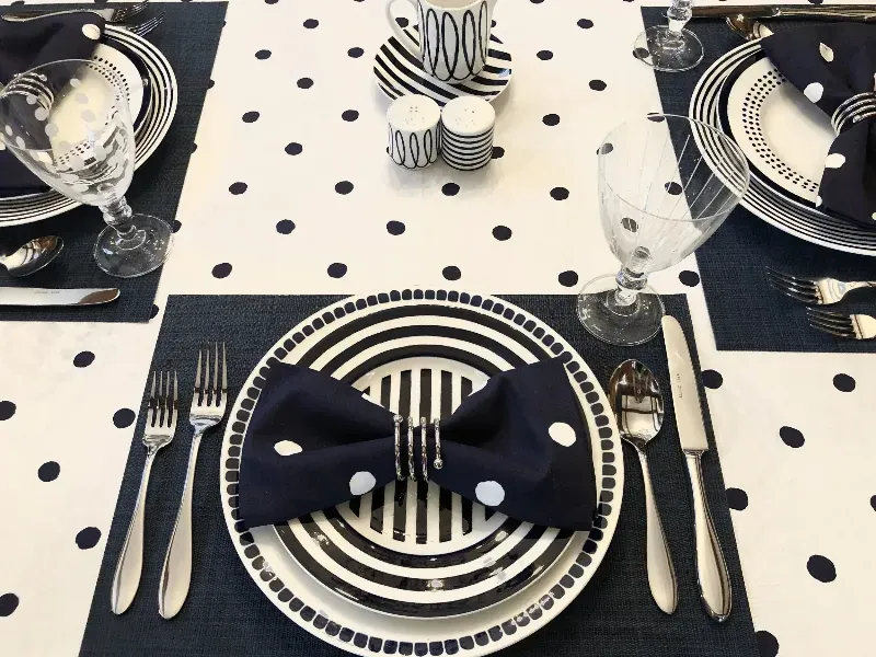 A black and white table setting with plates and silverware