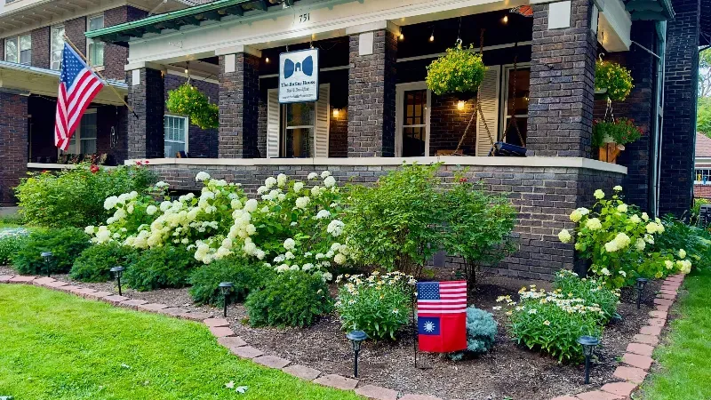 A house with a porch and a flag in front of it.