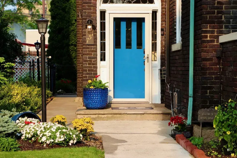 The front door of a brick house with a blue door