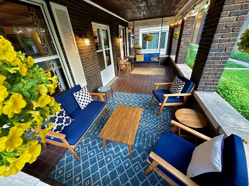 A porch with a couch and chairs on it