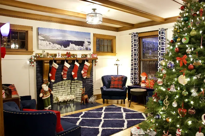 A living room decorated for christmas with a christmas tree and fireplace.