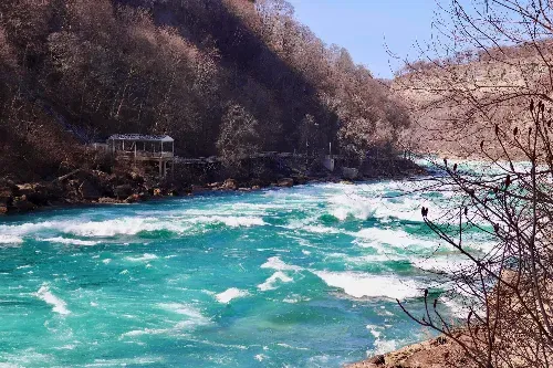 A river flowing through a valley surrounded by trees