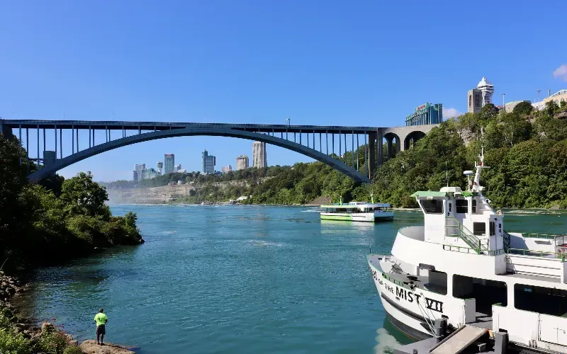 A boat is docked in front of a bridge over a river.