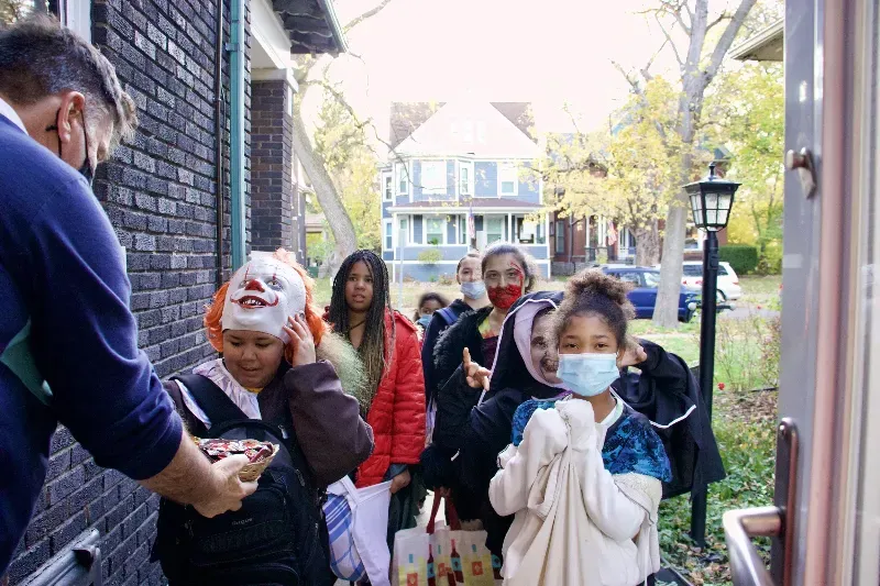 A group of people wearing masks are standing outside of a building.