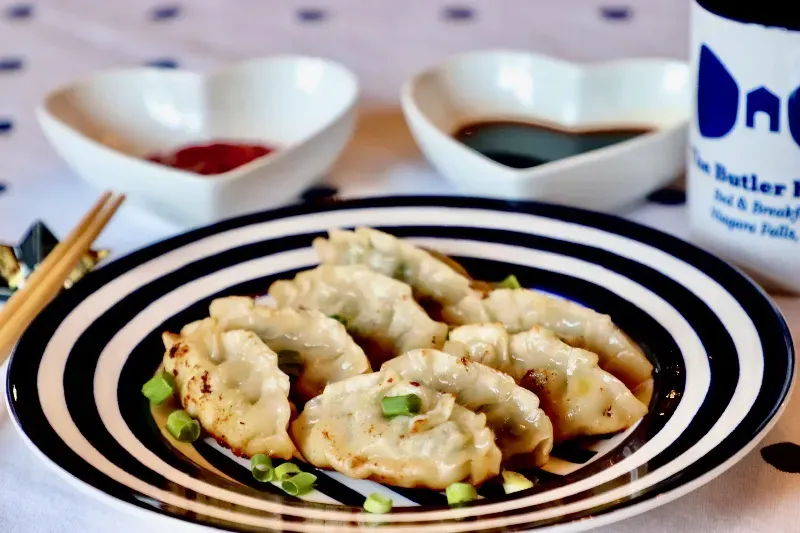 A black and white striped plate with dumplings on it