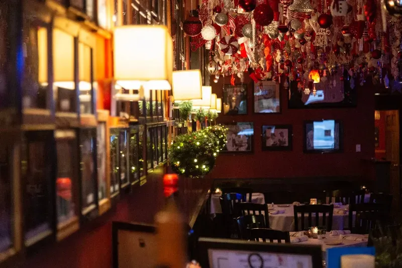 A restaurant with tables and chairs and a chandelier hanging from the ceiling.