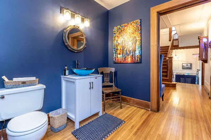A bathroom with a toilet , sink and mirror.
