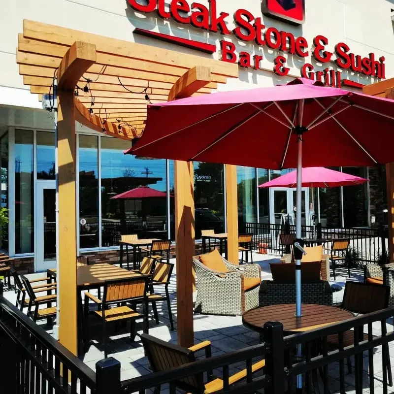 A steak stone and sushi restaurant with tables and chairs outside
