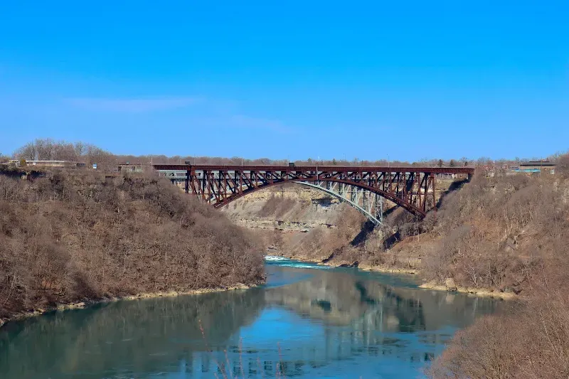 A bridge over a river in the middle of a valley.