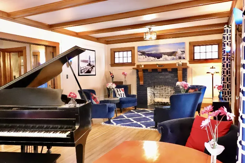 A living room with a piano and a fireplace
