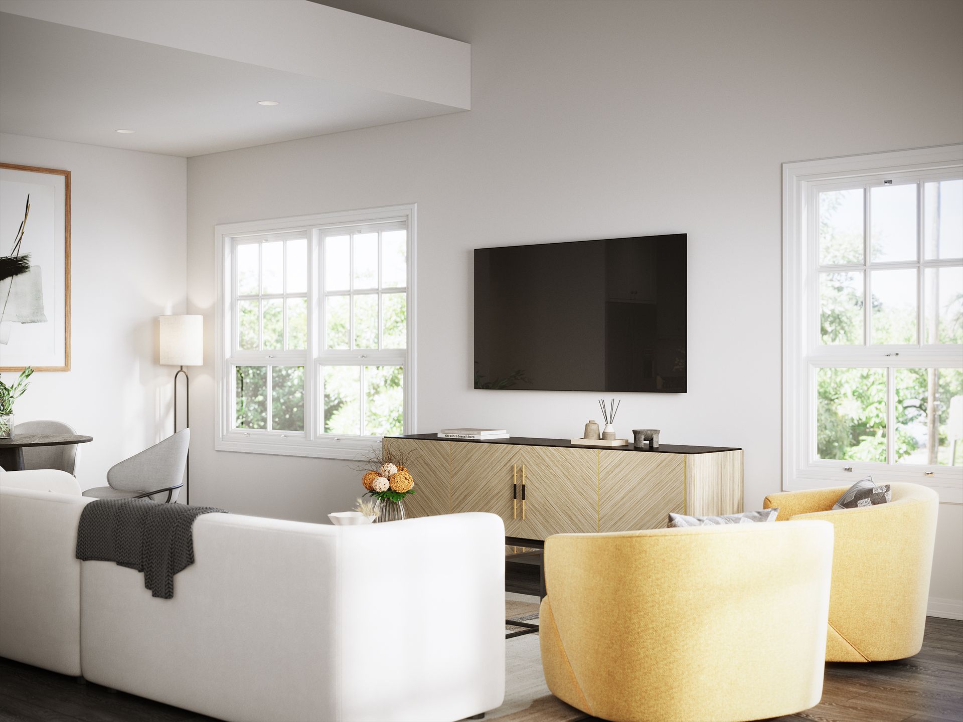 A living room with a white couch , yellow chairs , and a flat screen tv.