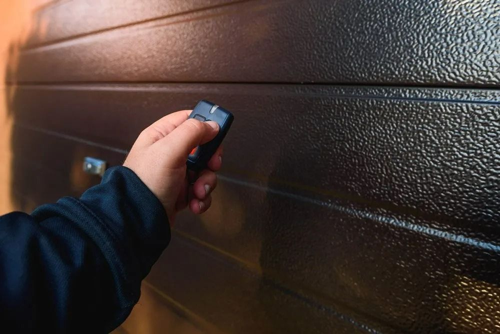 A Person is Using a Remote Control to Open a Garage Door — Suresafe Locksmiths in Glenvale, QLD
