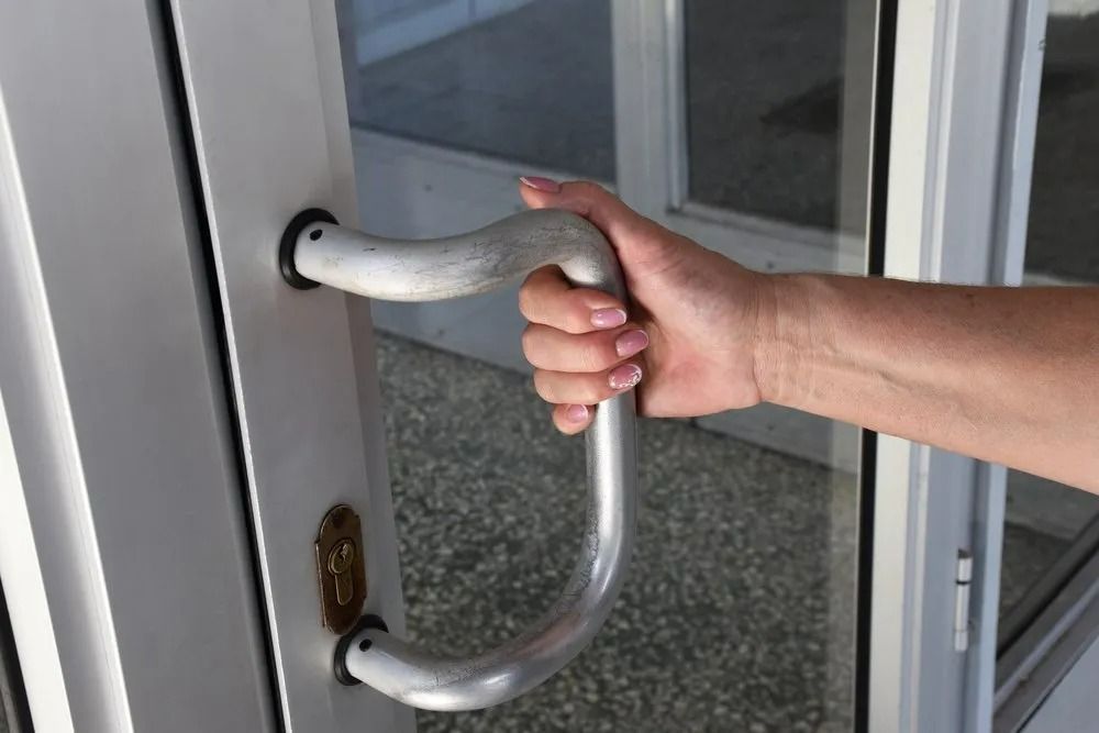 A Person is Opening a Door With a Handle — Suresafe Locksmiths in Glenvale, QLD