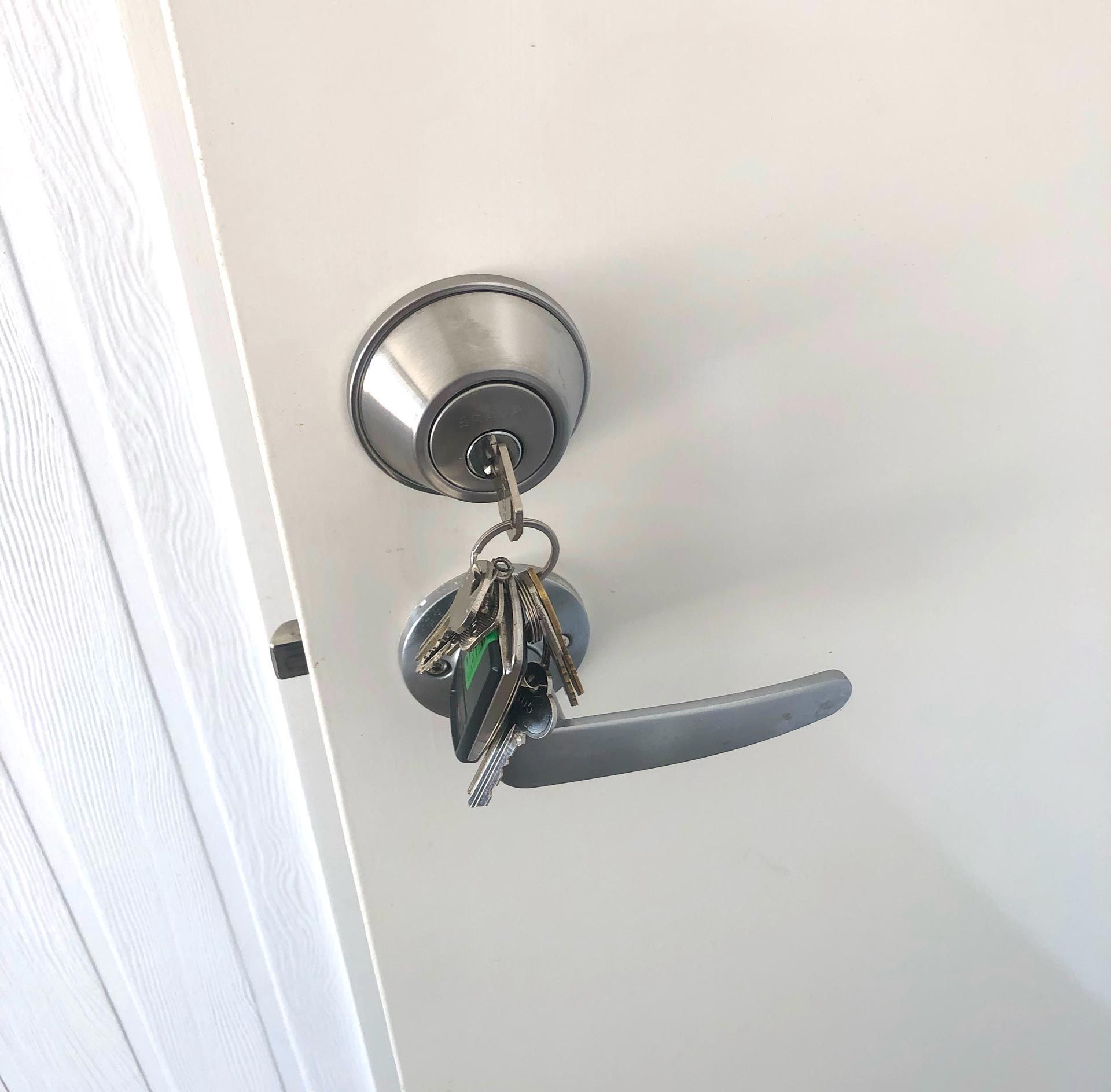 A Bunch of Keys Are Hanging From a Door Handle — Suresafe Locksmiths in Glenvale, QLD