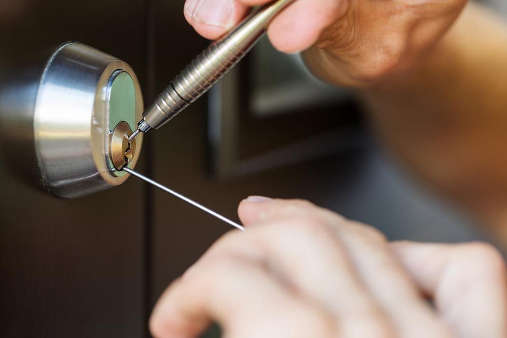 A Person is Using a Screwdriver to Open a Door Lock — Suresafe Locksmiths in Glenvale, QLD