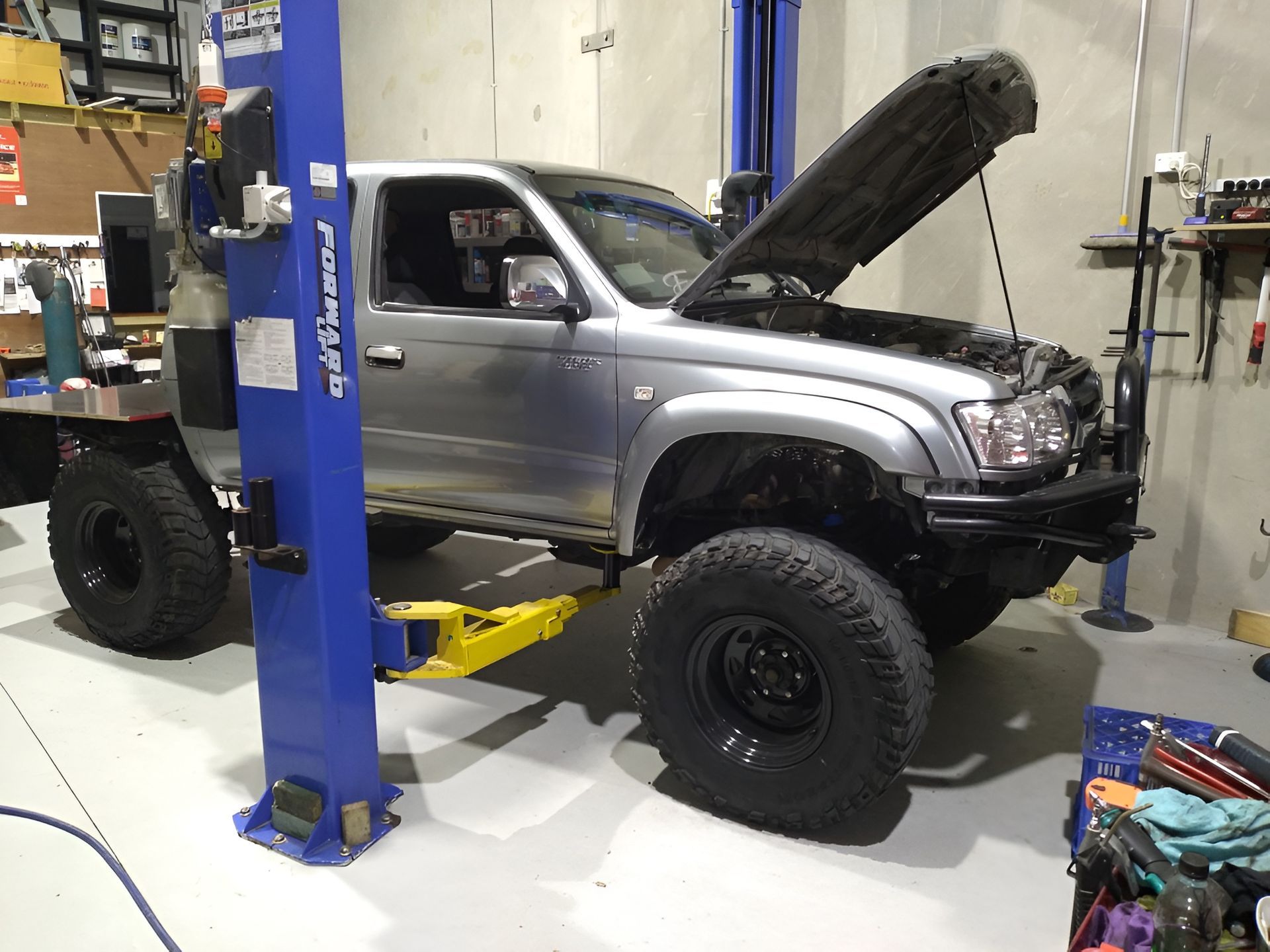 Silver Pickup Truck on a Lift With the Hood Open, Inside a Garage — Assassin Automotive Solutions in South Murwillumbah, NSW