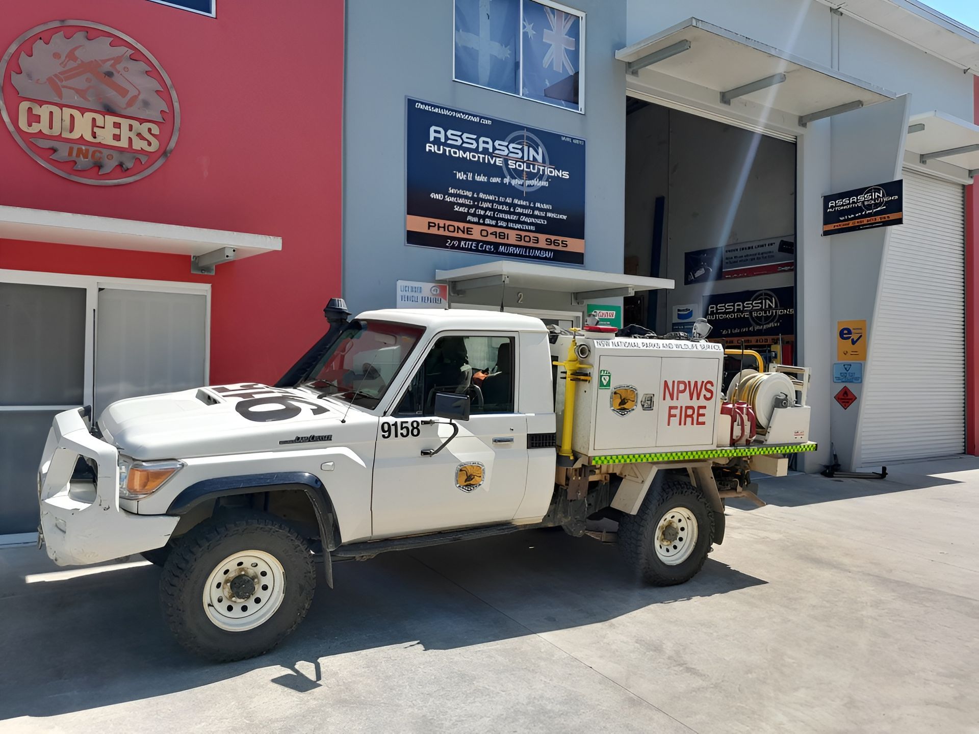 White Fire Truck Parked in Front of a Building With a Red Sign — Assassin Automotive Solutions in South Murwillumbah, NSW