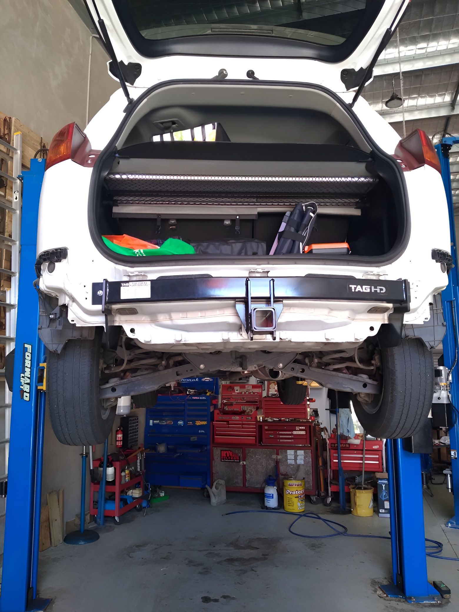 White Car Raised on a Lift in a Garage — Assassin Automotive Solutions in South Murwillumbah, NSW