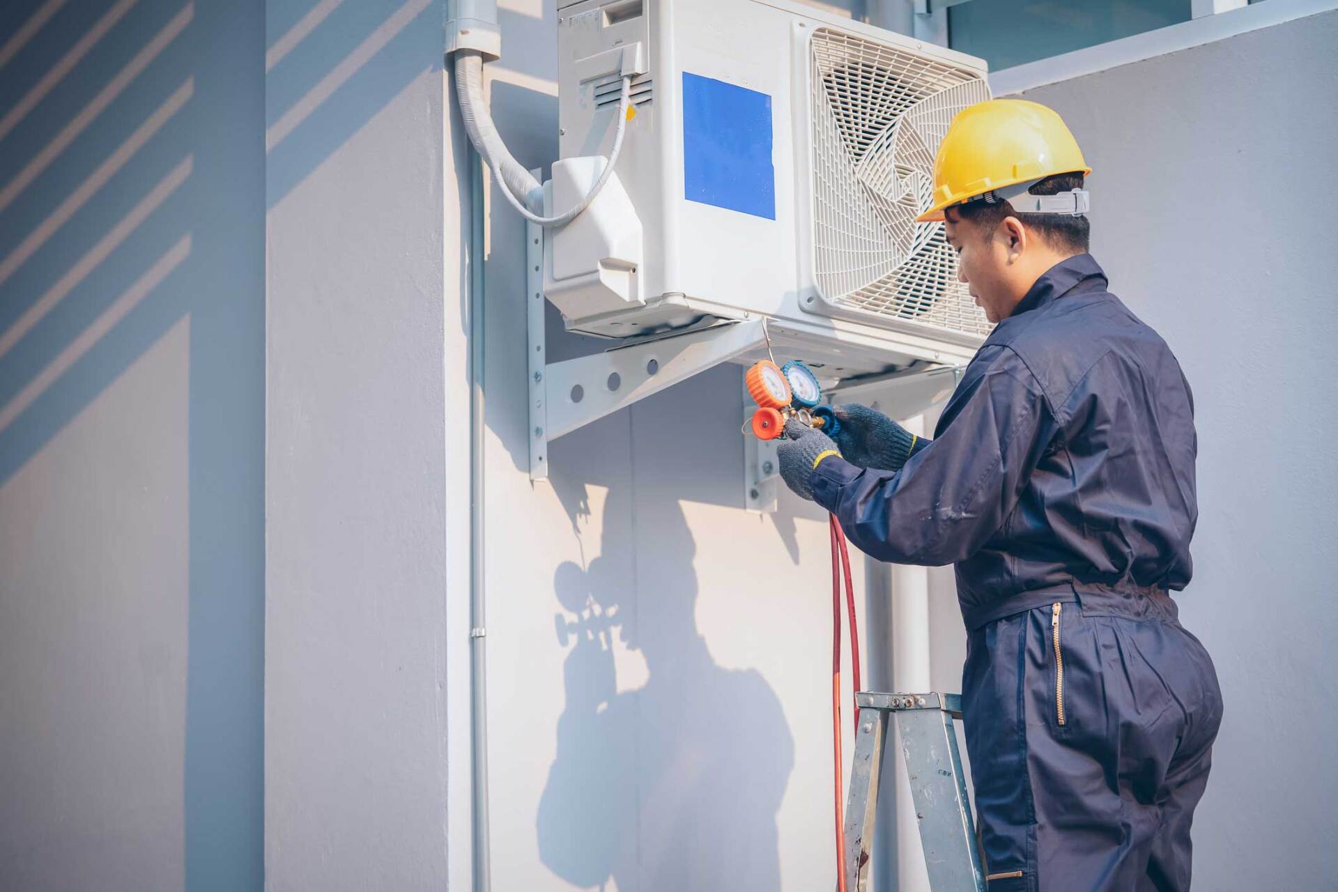 Technician Repairing Air Conditioner Outdoors — Clarksdale, MS — Temperature Control Inc