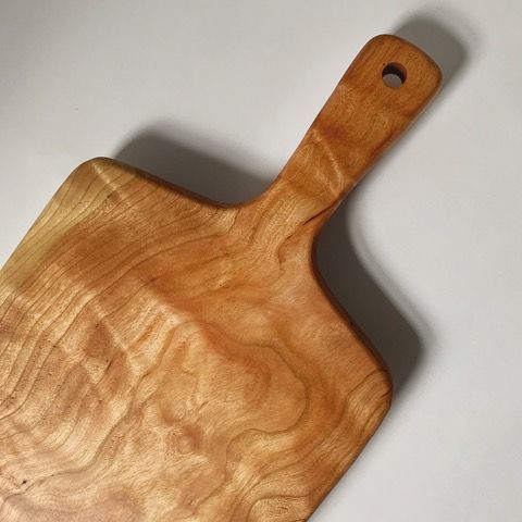 Wooden dining room with table, chairs, shelving, and large windows.