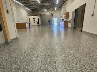 Une grande pièce vide avec un sol en béton dans un bâtiment.