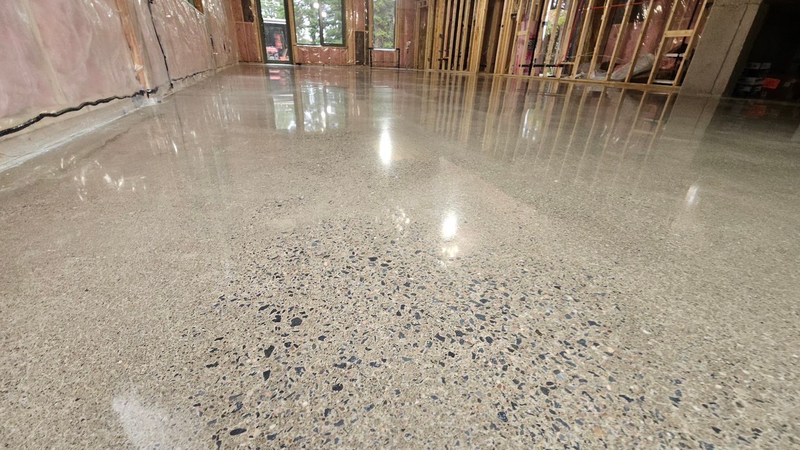 Un sol en béton brillant dans une pièce en construction.