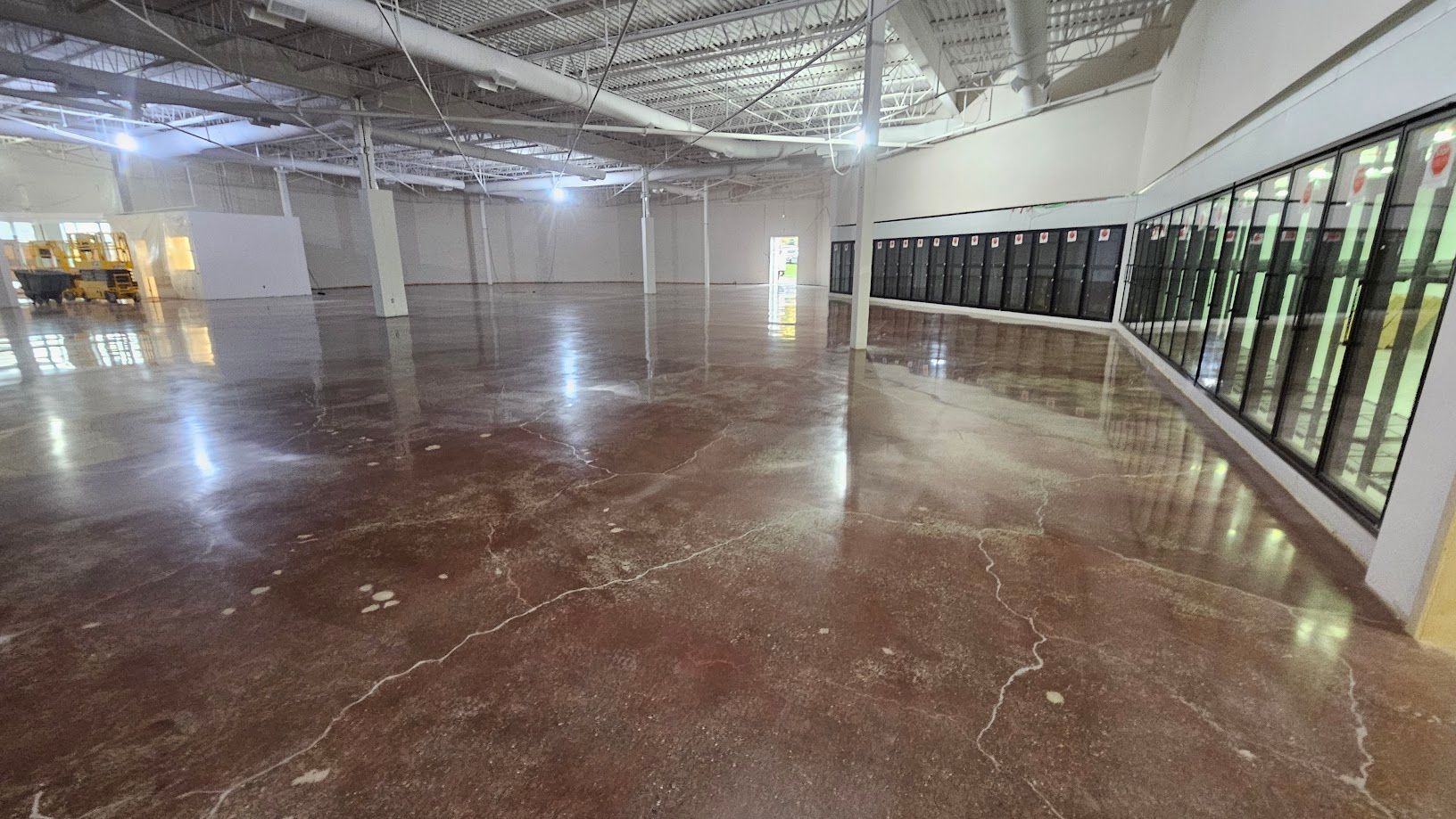 Une grande pièce vide avec un sol en béton brillant dans un bâtiment.