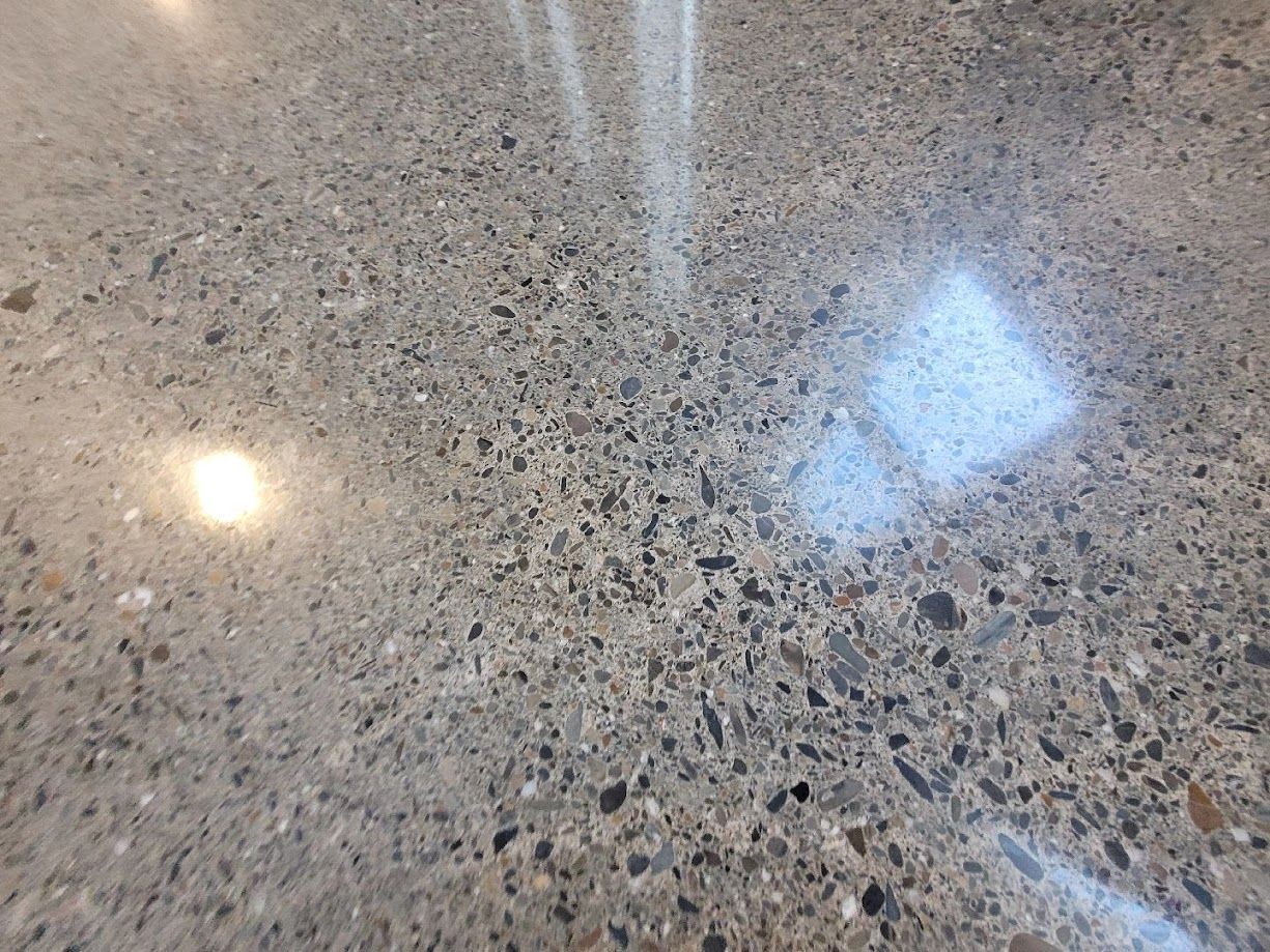 Un gros plan d'un sol en béton brillant avec un reflet de lumière.