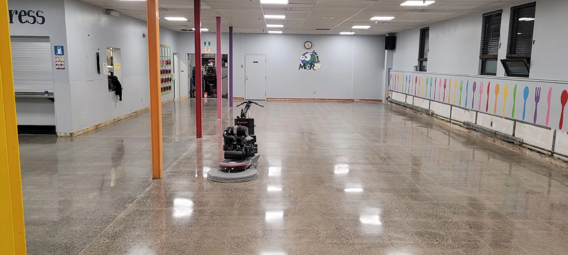 Une grande pièce vide avec un aspirateur sur le sol.