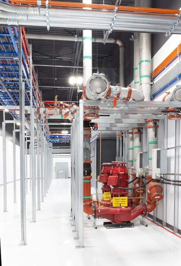 Une grande pièce avec beaucoup de tuyaux suspendus au plafond.