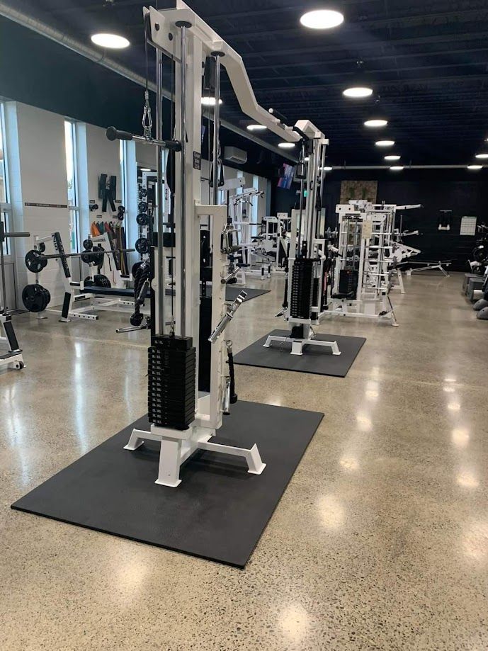 Une grande salle de sport remplie de nombreux équipements d'exercice.