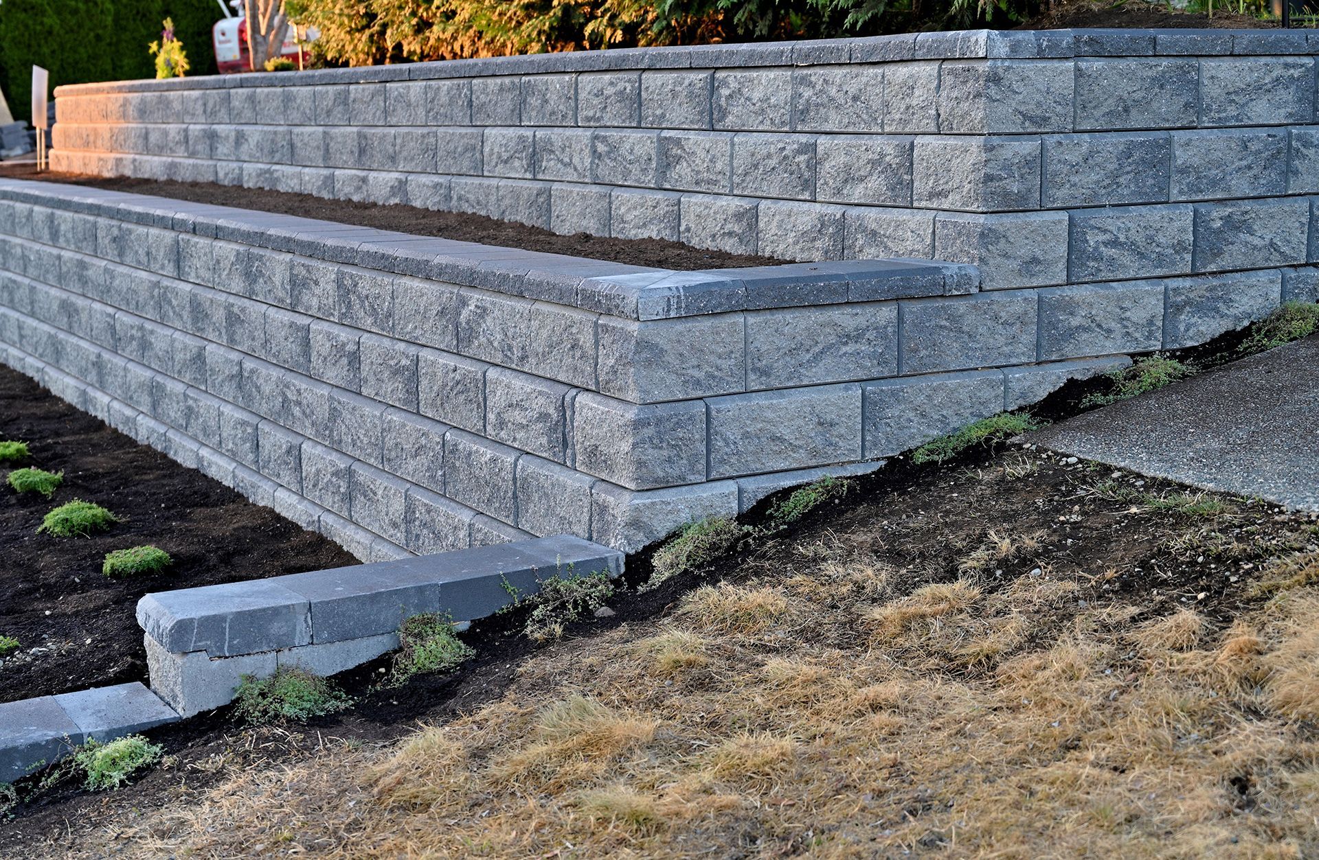 A brick wall is sitting on top of a dirt hill.