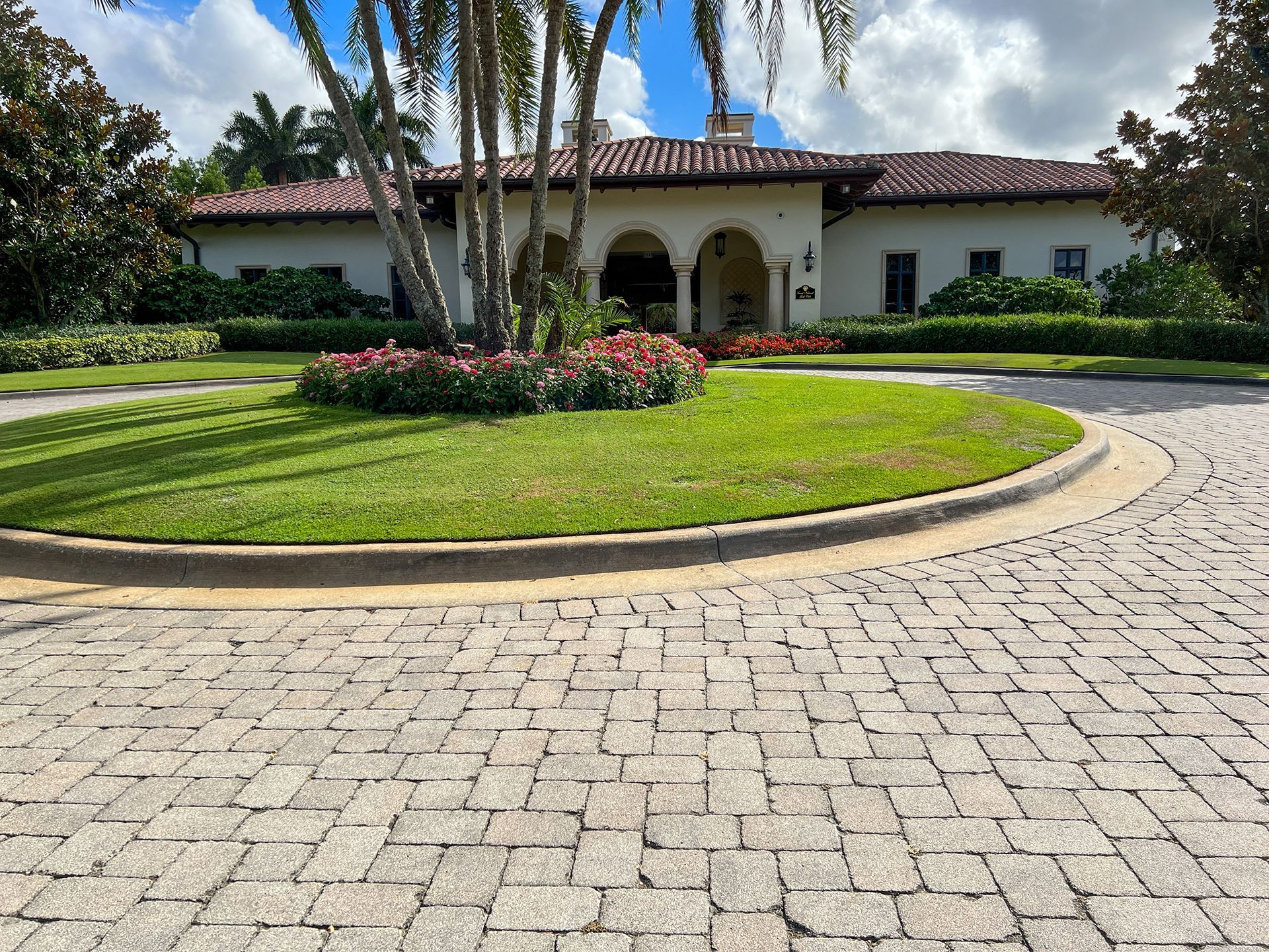 A large white house with a circular driveway in front of it