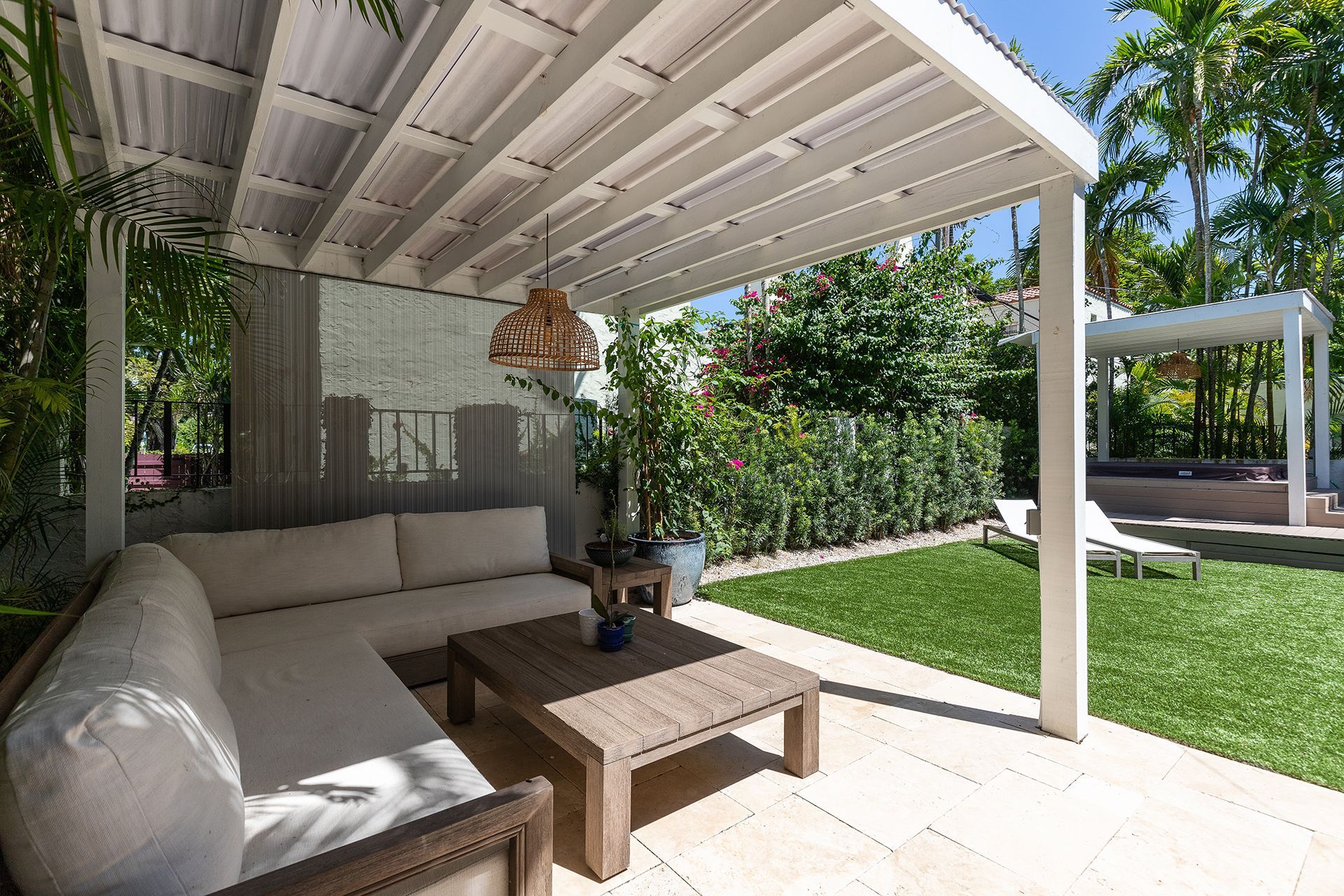 A patio with a couch and a table under a pergola.