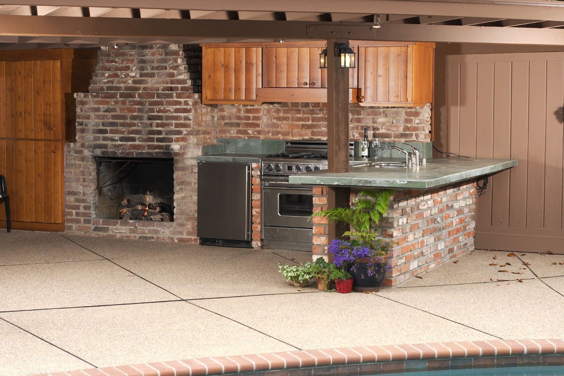 A kitchen with a stove and a fireplace next to a pool