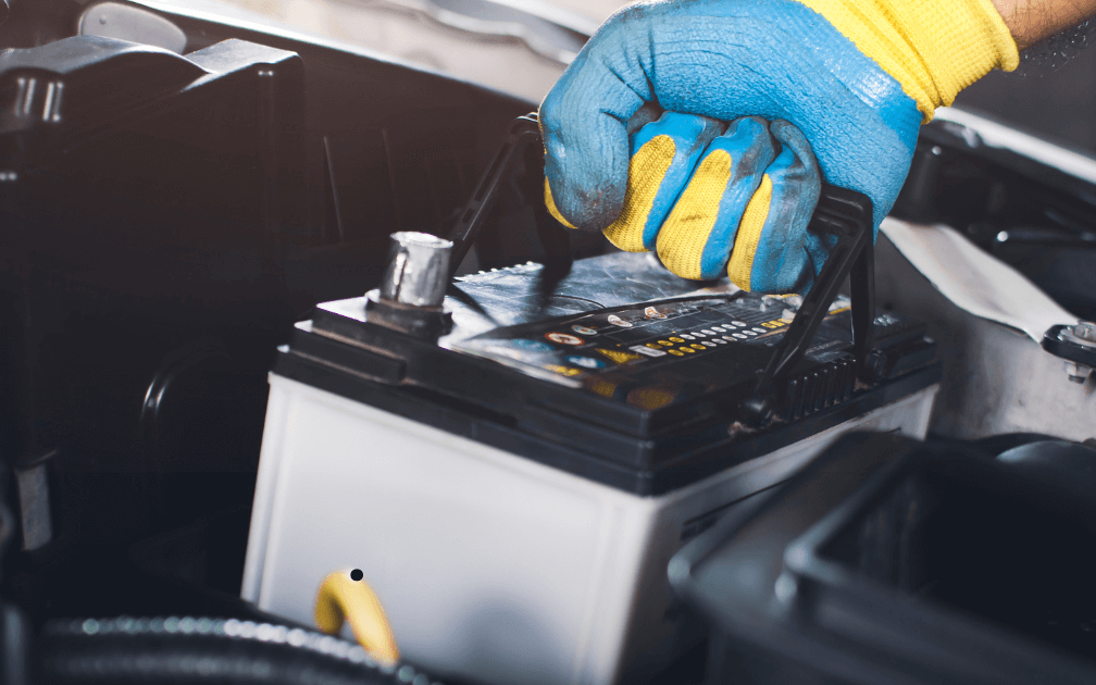 a mechanics changing a car battery 