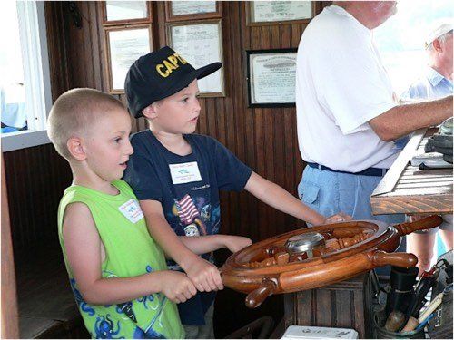 Young boys taking the helm under Captain Sonny's supervision during an exciting dolphin watch  (Dolphin & Nature Tour, Hilton Head Island, Sonny C Charters)