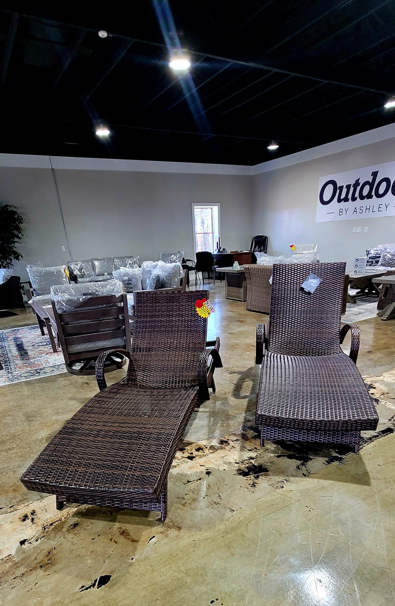 Indoor furniture showroom with wicker lounge chairs under bright ceiling lights