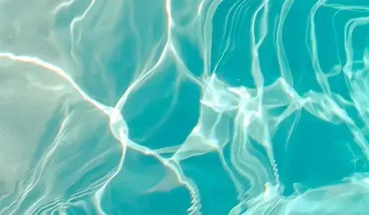 Rippling turquoise pool water with bright sunlight reflections