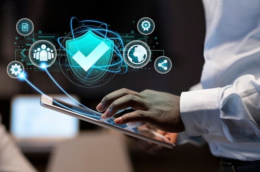 Business professional uses tablet with digital shield icons, representing integrated security technology.