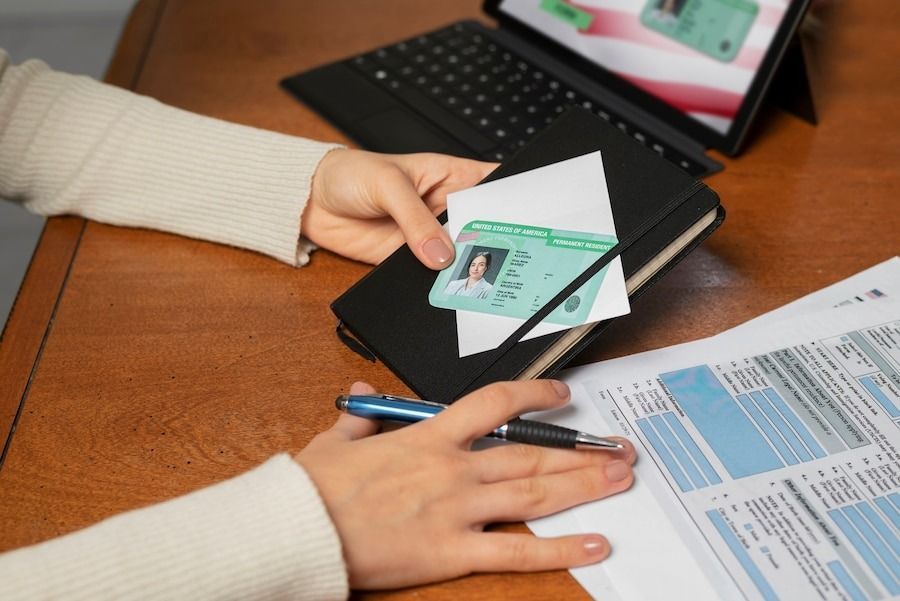 Hands reviewing ID and forms during background check oversight at a workspace