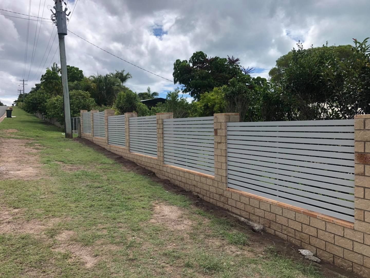 Barbed Wire Fence Surrounds a Road With Trees in the Background — Lange's Fencing and Landscaping Centre in Maryborough, QLD