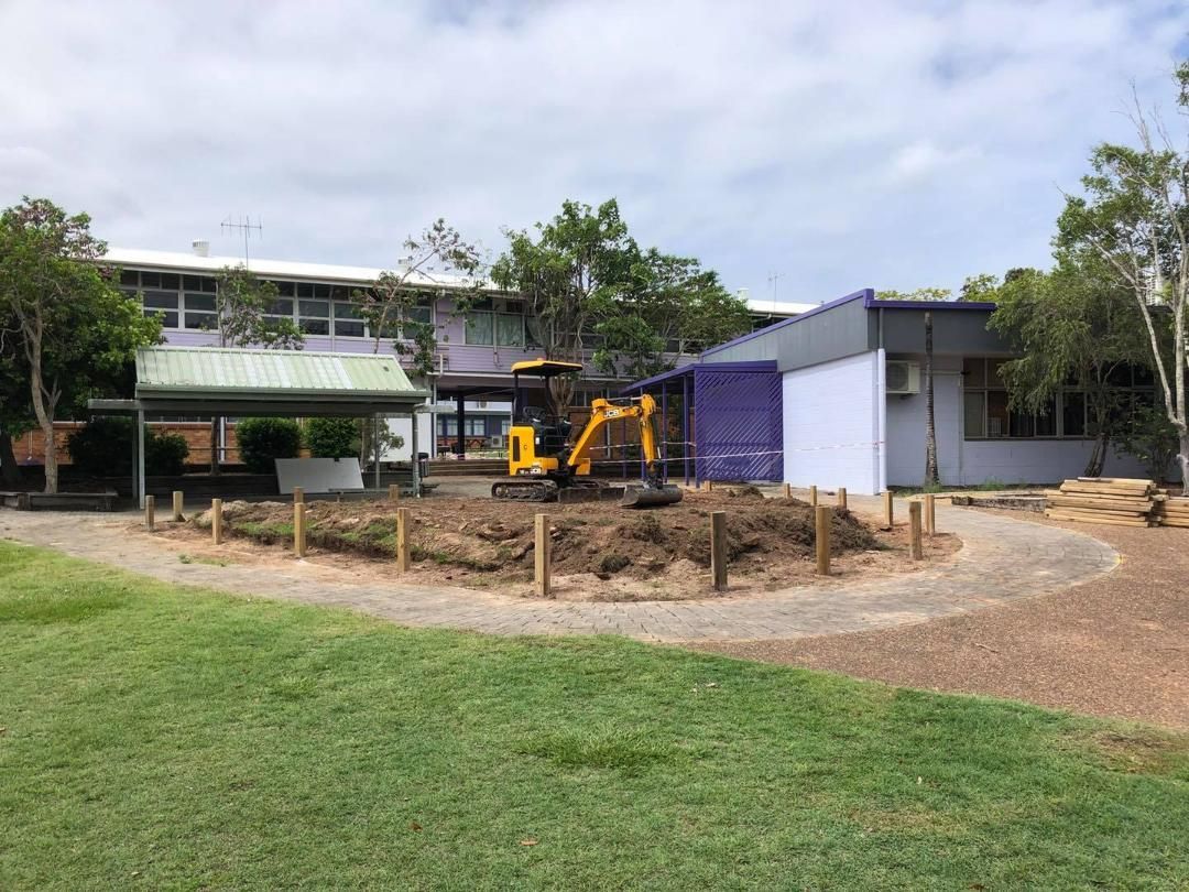 Yellow Excavator is Digging a Hole in Front of a Building — Lange's Fencing and Landscaping Centre in Island Plantation, QLD
