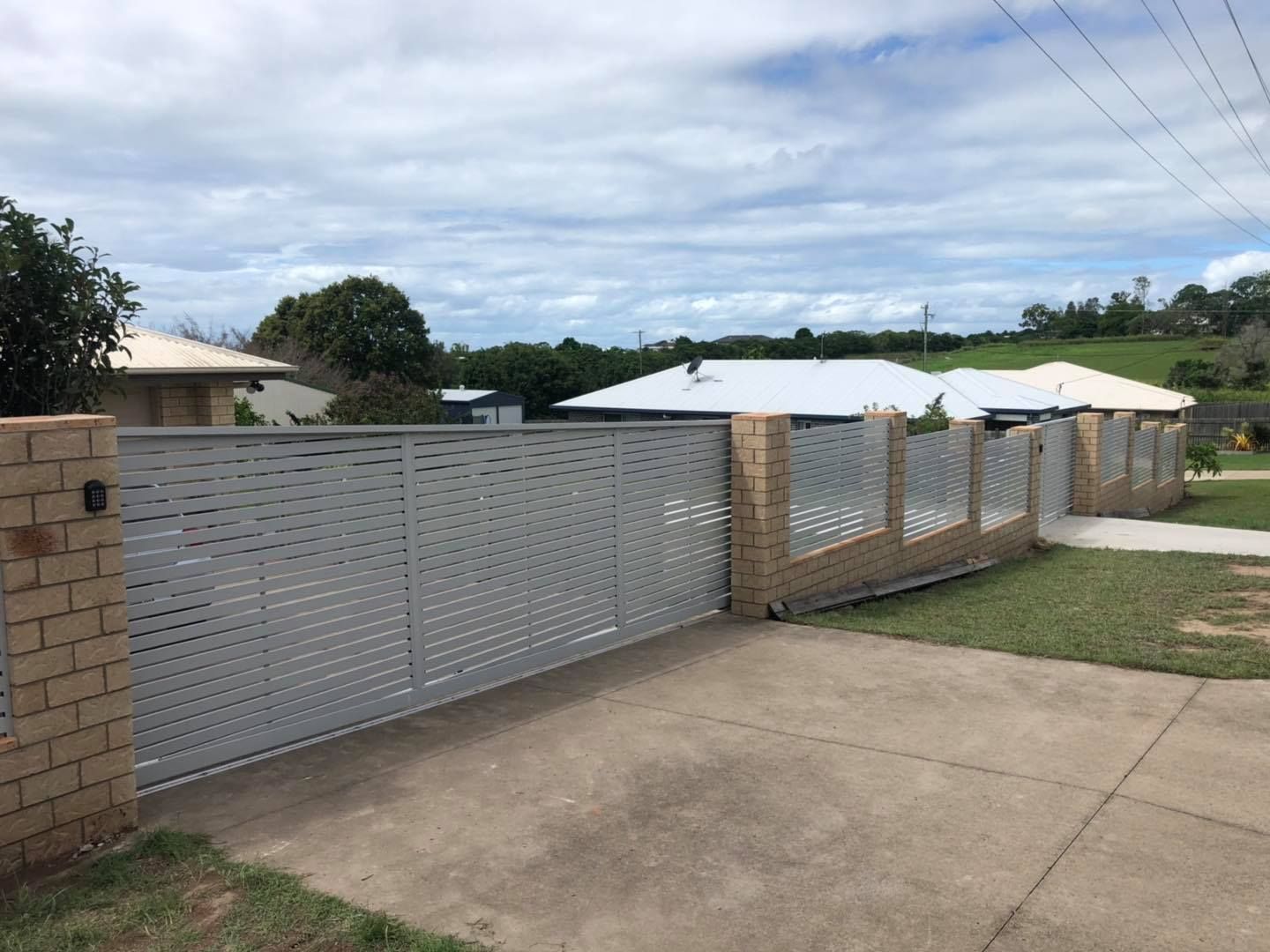 White Fence Surrounds a Driveway in Front of a House — Lange's Fencing and Landscaping Centre in Island Plantation, QLD